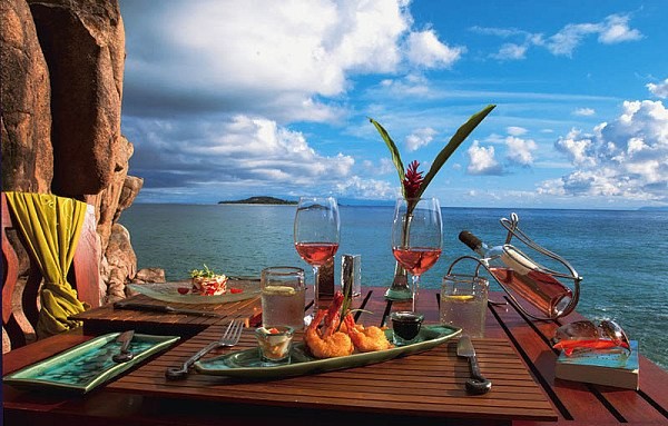 Открытка Скала, море, стол с вином и деликатесами